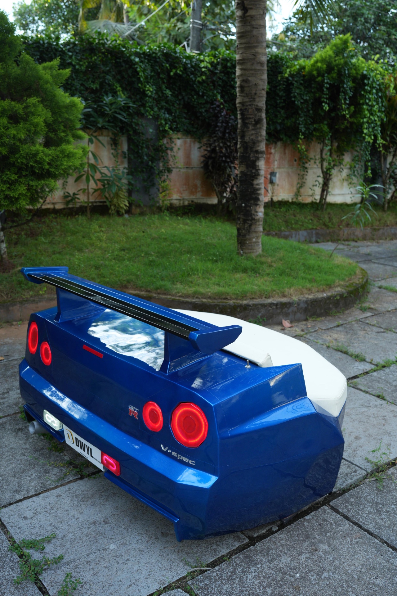 Artisan spray-painting a red Formula 1 body panel