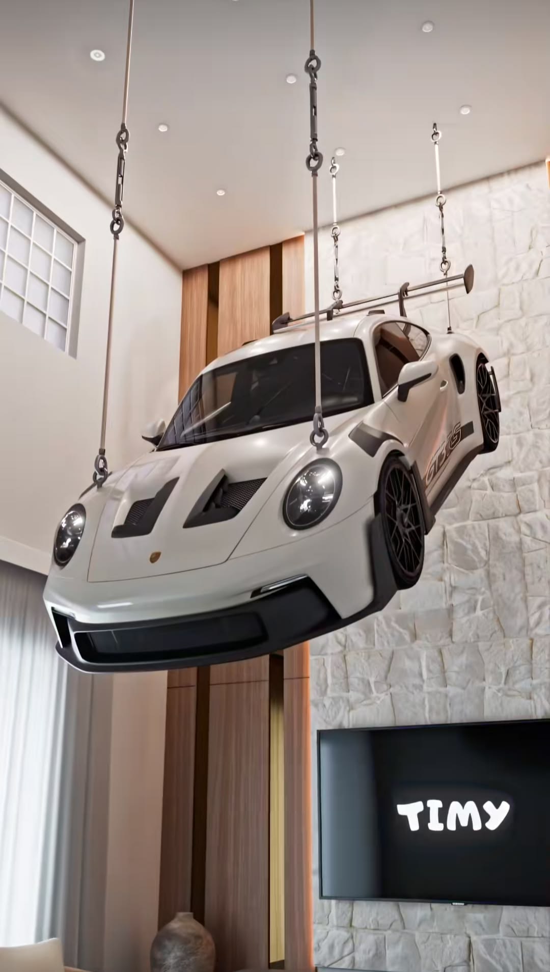 Full-scale suspended sports car installation in a gallery